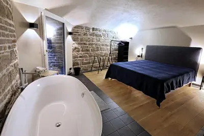 a bathroom with a tub and a bed in a room at American Loft in the Heart of Prague in Prague