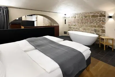 a bedroom with a large bed and a bath tub at American Loft in the Heart of Prague in Prague