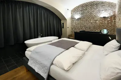 a bedroom with two beds and a bath tub at American Loft in the Heart of Prague in Prague