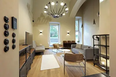 a living room with a couch and a chandelier at American Loft in the Heart of Prague in Prague