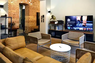 a living room with a couch and chairs and a tv at American Loft in the Heart of Prague in Prague