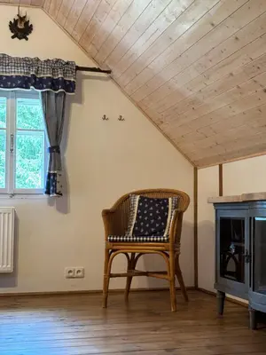 a chair in a room with a wooden ceiling at Hlučov Lesní Chalupa in Kokořín