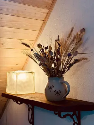 a vase with flowers sitting on a table with a book at Hlučov Lesní Chalupa in Kokořín