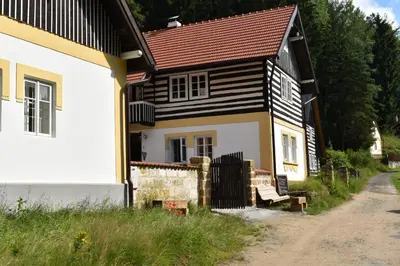a house with a bench in front of it at Hlučov - Penzion & Restaurace in Kaninský Dŭl