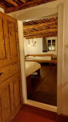 a room with a bed and a door with a mirror at Hlučov - Penzion & Restaurace in Kaninský Dŭl