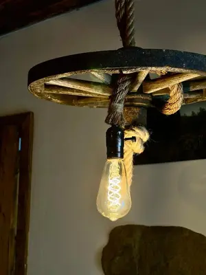 a light bulb hanging from a wooden chandelier at Hlučov - Penzion & Restaurace in Kaninský Dŭl