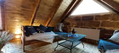 a living room with a couch and a table at Hlučov - Penzion & Restaurace in Kaninský Dŭl