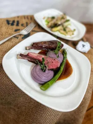 a plate of food with meat and vegetables on a table at Hlučov - Penzion & Restaurace in Kaninský Dŭl