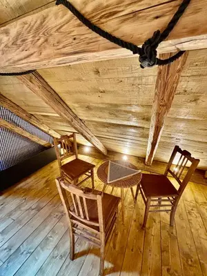 two chairs and a table in a room with a wooden ceiling at Hlučov - Penzion & Restaurace in Kaninský Dŭl