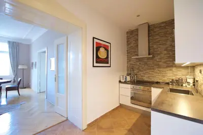 a kitchen with white cabinets and a brick wall at Beautiful view on the Prague castle close to the centre in Prague