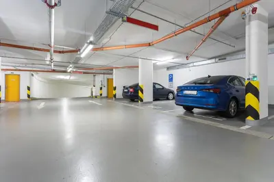 a parking garage with two cars parked in it at Yellow apartment with PARKING in Prague