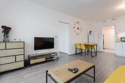 a living room with a flat screen tv and a table at Yellow apartment with PARKING in Prague