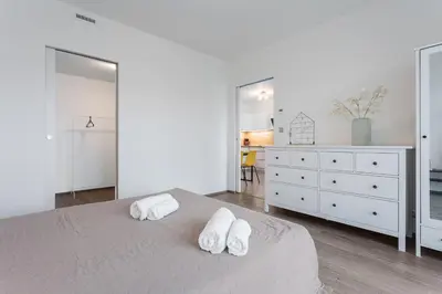 a white bedroom with two towels on a bed at Yellow apartment with PARKING in Prague