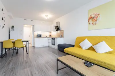 a living room with a yellow couch and a table at Yellow apartment with PARKING in Prague