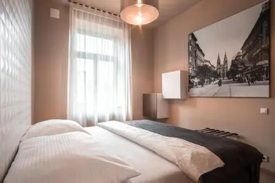 a bedroom with a bed and a large window at Aparthotel Rimska 14 in Prague