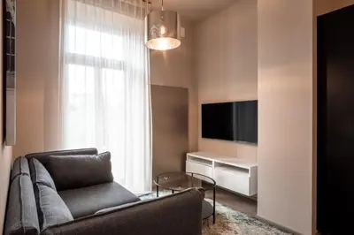 a living room with a couch and a tv at Aparthotel Rimska 14 in Prague
