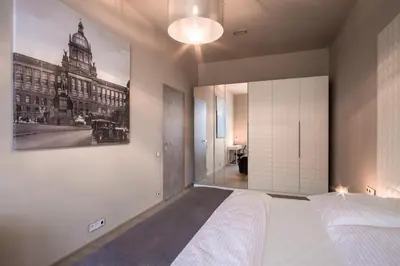 a bedroom with a bed and a picture on the wall at Aparthotel Rimska 14 in Prague