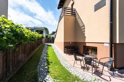 a garden with a table and chairs next to a building at Wine Pension Prague in Prague