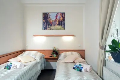 a room with two beds and a desk at Wine Pension Prague in Prague