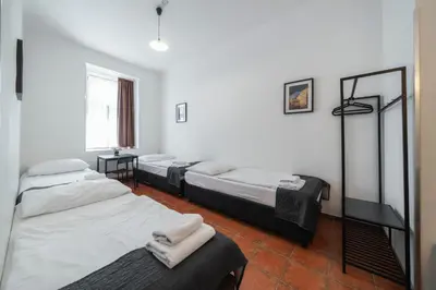 a room with four beds in a room with a window at Pension 15 Homér in Prague