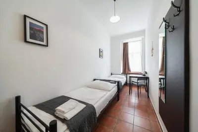 a bedroom with two beds and a table in it at Pension 15 Homér in Prague