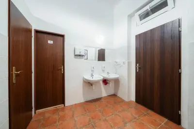 a bathroom with a sink and two toilets in it at Pension 15 Homér in Prague