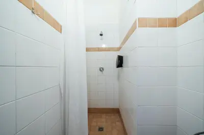 a bathroom with a shower with white tiles at Pension 15 Homér in Prague