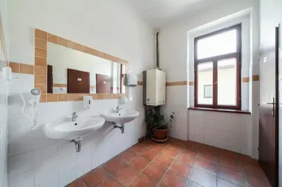 a bathroom with two sinks and a window at Pension 15 Homér in Prague