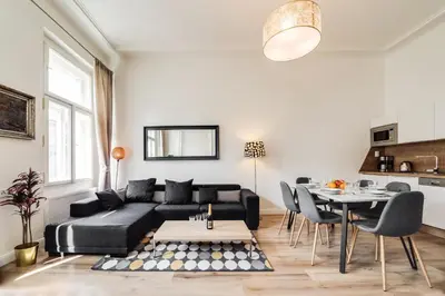 a living room with a black couch and a table at Charles Bridge - 3 bedroom Apartment - Old Town in Prague