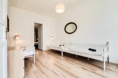 a white room with two beds and a mirror at Charles Bridge - 3 bedroom Apartment - Old Town in Prague