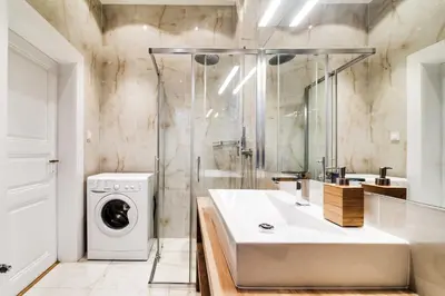 a bathroom with a sink and a washing machine at Charles Bridge - 3 bedroom Apartment - Old Town in Prague