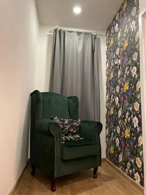 a green chair in a room with a window at Nice and cozy apartment right at TV tower in Prague