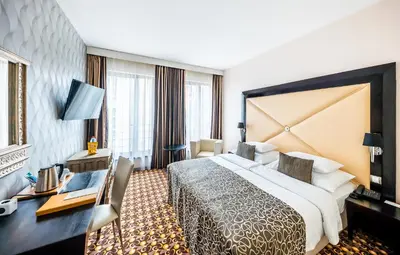 a hotel room with a large bed and a desk at Grandior Hotel Prague in Prague