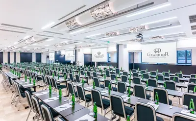 a conference room with tables and chairs and a stage at Grandior Hotel Prague in Prague