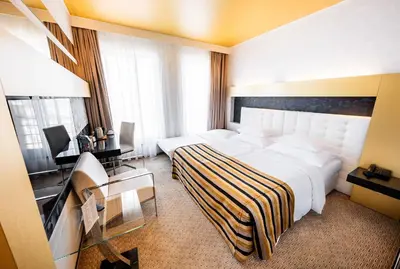 a hotel room with a large bed and a television at Grandior Hotel Prague in Prague