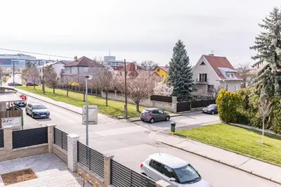 a city street with cars parked on the road at Home Le Fame in Prague