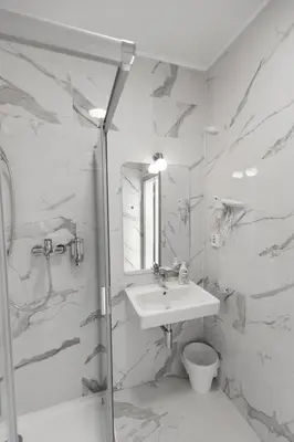 a white bathroom with a sink and a shower at Home Le Fame in Prague