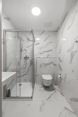 a white bathroom with a shower and a toilet at Home Le Fame in Prague