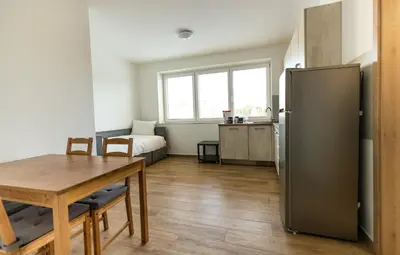 a kitchen with a table and a refrigerator at Home Le Fame in Prague