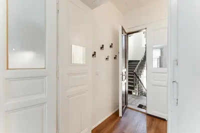 a hallway with white walls and a door with a mirror at Spacious cozy 2bds apt in center - stp4 in Prague