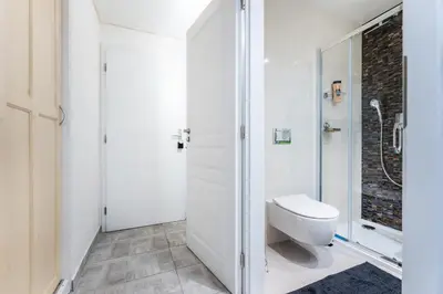 a white bathroom with a toilet and a shower at Get Prague Flat Stepanska in Prague