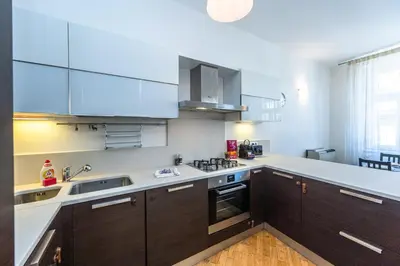 a kitchen with brown cabinets and white counter tops at Wishlist Old Prague Residences - Haštalská in Prague