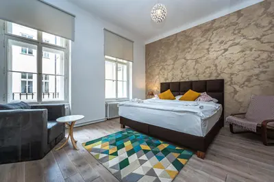 a bedroom with a bed and a chair and a couch at Wishlist Old Prague Residences - Haštalská in Prague