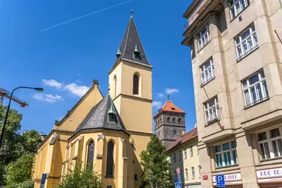 a church with a steeple next to a building at Wishlist Old Prague Residences - Haštalská in Prague
