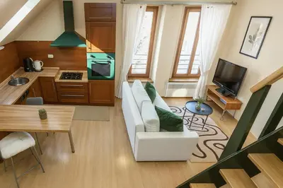 a living room with a white couch and a kitchen at Wishlist Old Prague Residences - Haštalská in Prague
