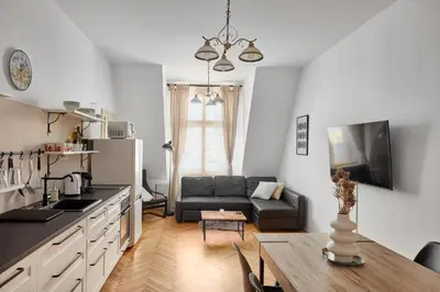 a kitchen and living room with a couch and a table at Prague Days - One-bedroom Apartment with View of Castle from Balcony near Wenceslas Square in Prague