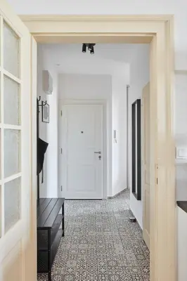 a hallway with white walls and a door at Prague Days - One-bedroom Apartment with View of Castle from Balcony near Wenceslas Square in Prague