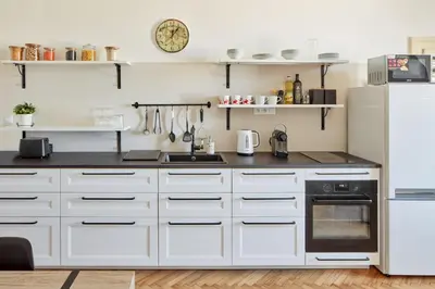 a kitchen with white cabinets and a refrigerator at Prague Days - One-bedroom Apartment with View of Castle from Balcony near Wenceslas Square in Prague
