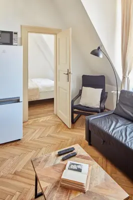 a living room with a couch and a table at Prague Days - One-bedroom Apartment with View of Castle from Balcony near Wenceslas Square in Prague