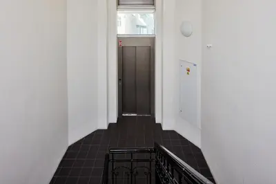 a hallway with a black door and a tile floor at Prague Days - One-bedroom Apartment with View of Castle from Balcony near Wenceslas Square in Prague